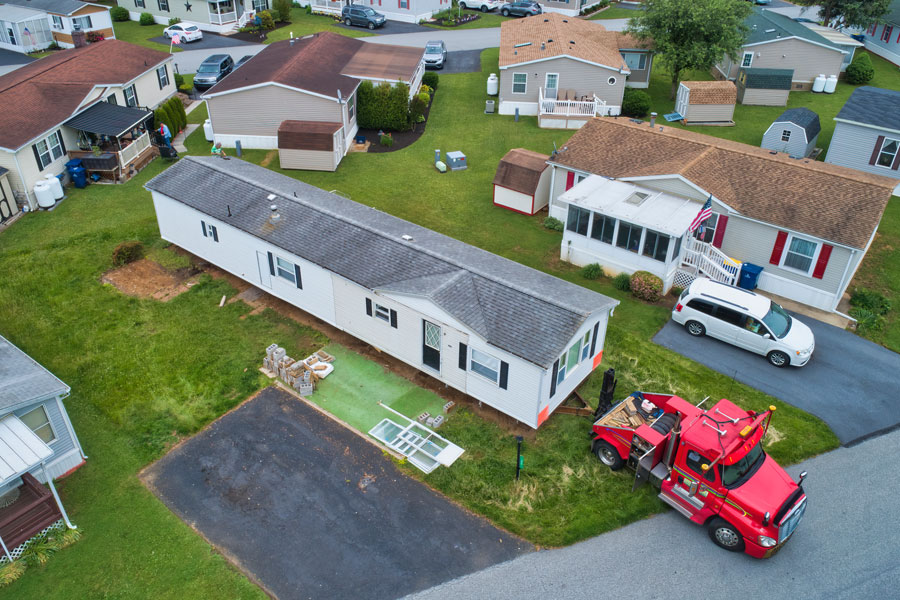 According to Manufactured Home News, sales continue to grow through June of 2022 over conventional housing. Seen here, crane is lifting and transporting modular home. File photo: Greg Kelton, ShutterStock.com, licensed.